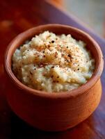 Close up of Creamy Mashed Potatoes in Rustic Clay Bowl with Spices. photo
