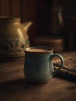 A Warm Mug of Comfort Close Up of a Rustic Blue Ceramic Mug on a Wooden Table. photo