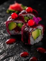 Close up of gourmet beet sushi rolls with avocado and garnished with red berries. photo