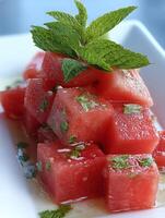 Refreshing Watermelon and Mint Salad Close Up of Cubes with Fresh Herbs. photo