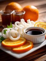 Delicious Squid Rings with Orange Slices and Soy Sauce. A Close Up of an Appetizing Dish. photo