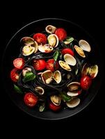 Overhead View of Delicious Black Pasta with Clams and Cherry Tomatoes. photo