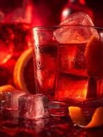 Close up of a refreshing red cocktail with ice cubes and orange zest. photo