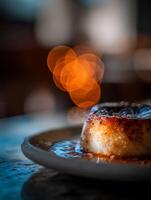 Close up of Creamy Caramel Flan Dessert on a Plate with Bokeh Background. photo