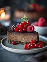 Delicious Chocolate Cheesecake Slice with Fresh Berries. A close up shot of a decadent dessert topped with red currants and raspberries. photo