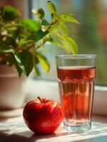 Sunlit Glass of Apple Juice with Fresh Red Apple. A refreshing summer beverage. photo