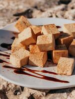 Close up of Pan-Fried Tofu Cubes with Sweet Sauce on a Plate. photo