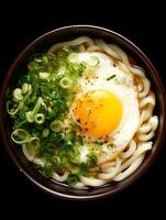 Delicious Udon Noodle Soup with Fried Egg and Green Onions. A close up overhead shot of a bowl of Japanese udon noodles. photo