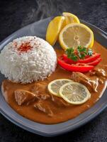 Aromatic Chicken Curry with Rice and Lemon Garnish A Close Up Food Photography Image. photo