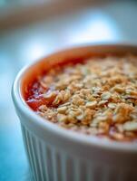 Close Up of Delicious Oat Crumble Topping on Red Fruit Dessert in White Ramekin. photo