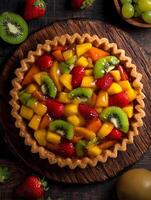 Delicious Fruit Tart with Mango, Kiwi, and Strawberry Filling. A top-down close up shot of a freshly baked fruit tart on a rustic wooden surface. photo