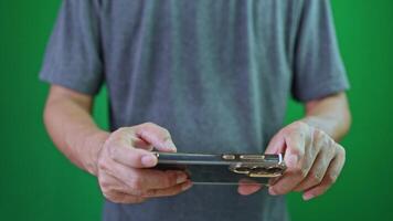 jovem homem levando foto ou grampo meios de comunicação com dele Smartphone, em croma chave verde tela, fechar-se, mão estão usando uma telefone, levar uma foto e com Móvel telefone video