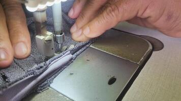 sewing machine with female hands close-up. a seamstress is sewing a seam on a sewing machine, sewing machine with fabric and hands woman tailor, domestic work industry and hobby tailor concepts video