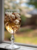 Glass of Infused Water with Spring Blossoms on Windowsill. photo