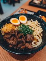 Delicious Beef Udon Noodle Soup with Soft Boiled Eggs and Pickled Onions. photo
