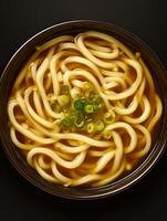 Overhead close up of a bowl of udon noodle soup with green onions. photo