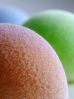Close up of a Textured Orange Sphere with Blurred Green and Blue Backgrounds. photo