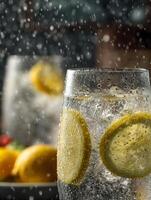 Refreshing Sparkling Water with Lemon Slices and Ice. Close up of a glass filled with a bubbly beverage. photo