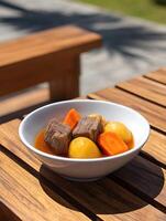 Delicious Beef Stew in a Bowl on a Wooden Table. A close up photo of a hearty beef stew with potatoes and carrots, perfect for a cozy meal.