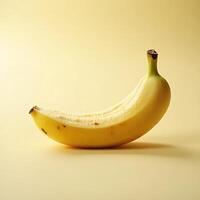 Single Ripe Banana Partially Peeled on Yellow Background photo