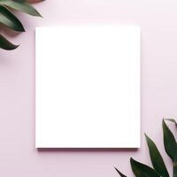 A white square surrounded by green leaves on a pink background photo