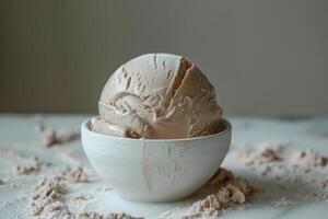 On the table, there is a bowl filled with delicious chocolate ice cream photo