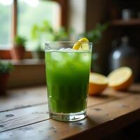 Drinking Green Juice with Lemon and Ice on Wooden Table photo