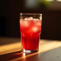 Refreshing Red Drink with Ice Cubes on Table in Sunlight photo