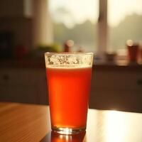Orange Drink in Glass Sitting on Table in Warm Light photo