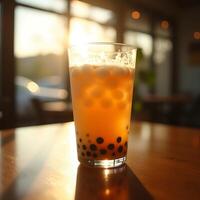Iced Tea with Tapioca Pearls and Boba on Table in Sunlight photo