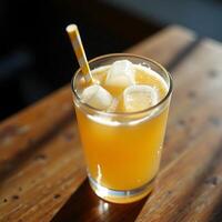 Drinking Orange Beverage with Ice and Straw on Wooden Surface photo