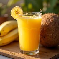 Pouring Fresh Tropical Juice in Glass with Banana and Coconut photo