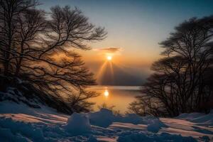The sun is setting over a lake and snow covered trees photo