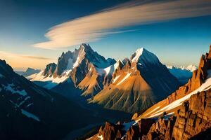 A mountain range with snow capped peaks at sunset photo