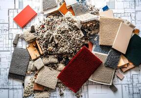Pile of discarded flooring samples on architectural blueprints. photo