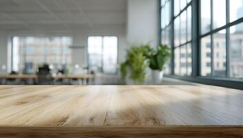 Light brown wooden table surface in front of a blurred office space with large windows. photo