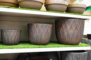 Textured stone planters displayed on shelves in a garden store.Rustic pots. photo
