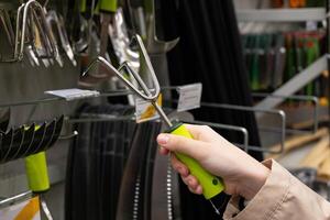 Person examining gardening tools in a hardware store. Customer product. photo