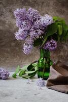 Cup of tea, straw hat, open book and lilac basket, spring still life. photo