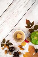 Autumn, fall leaves, hot steaming cup of coffee and a warm scarf on wooden table background. Seasonal, morning coffee, Sunday relaxing and still life concept. photo
