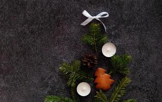 photograph of a Christmas setting with heart-shaped candy canes, gingerbread cookies, cinnamon sticks, pine sprigs, candles photo