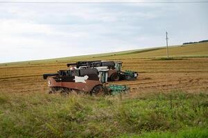 Combine harvesters working in a field with grassy foreground. photo