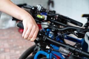 Hand gripping the brake lever of a bicycle handlebar in close-up. photo