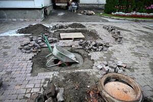 Low angle view of male hands measuring for precise pavement of the outside patio or sidewalk. Construction industry and renovation. photo
