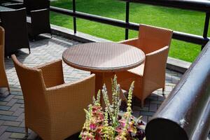 Outdoor wicker furniture in a lush garden. photo