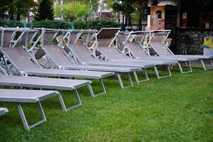 Outdoor lounge chairs near a poolside area. photo