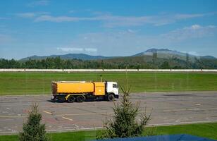 Airplane refueling at airport with mountain backdrop. photo