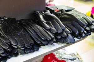 Multiple pairs of black leather gloves on a store shelf. photo