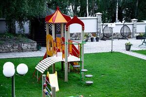 Colorful playground with slide and climbing structure in park. photo