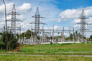 Power substation with high-voltage towers and cables in a rural area.. photo